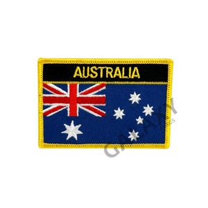 May include: An embroidered patch featuring the Australian flag with the word "AUSTRALIA" in a black banner above the flag. The flag is blue with a Union Jack in the top left corner and six white stars in the bottom right corner.