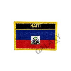 May include: An embroidered patch featuring the flag of Haiti. The patch is rectangular and has a yellow border. The flag is blue and red with a coat of arms in the center. The words "HAITI" are printed in yellow on a black background above the flag.