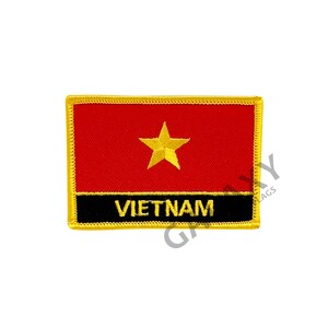 Op de afbeelding: Een geborduurde patch met de vlag van Vietnam, met een rode achtergrond, een gele ster en het woord "VIETNAM" in gele letters.