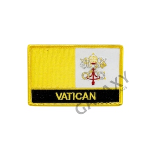 Könnte beinhalten: Ein gelber und weißer gestickter Aufnäher mit der Flagge des Vatikans und dem Wort "VATICAN" in goldenen Buchstaben.