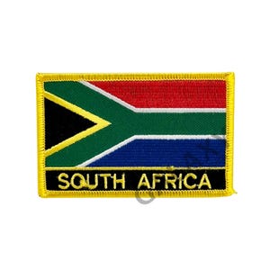 Puede incluir: Un parche bordado amarillo con la bandera de Sudáfrica y el texto "SOUTH AFRICA" en negro.