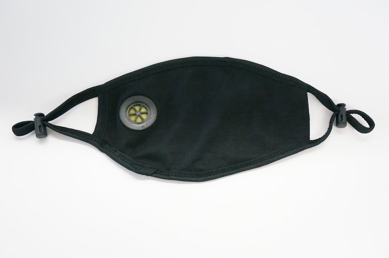 May include: Black face mask with a round, gray filter valve. The mask has adjustable elastic ear loops.