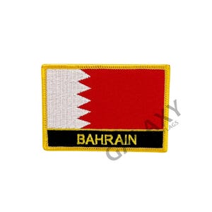 May include: An embroidered patch featuring the flag of Bahrain. The flag is red with a white serrated triangle on the hoist side. The patch has a black border with the word "BAHRAIN" in gold lettering.