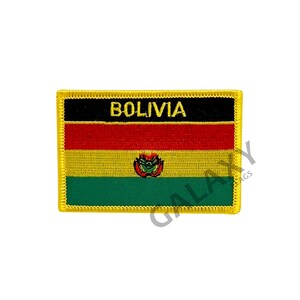 May include: A yellow embroidered patch with the Bolivian flag. The flag has three horizontal stripes: red, yellow, and green. The yellow stripe has a coat of arms in the center. The patch has a black border with the word "BOLIVIA" in yellow lettering.