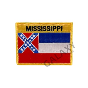 Pode incluir: Um remendo bordado amarelo com a bandeira do estado do Mississippi. A bandeira apresenta um campo vermelho com um cantão azul que contém uma cruz branca com 13 estrelas brancas. As palavras "MISSISSIPPI" são bordadas em preto em uma faixa amarela acima da bandeira.