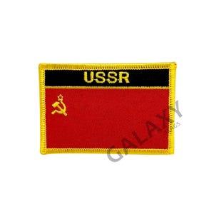 May include: A red embroidered patch with a gold hammer and sickle and a black banner with the word "USSR" in gold lettering. The patch is surrounded by a gold border.