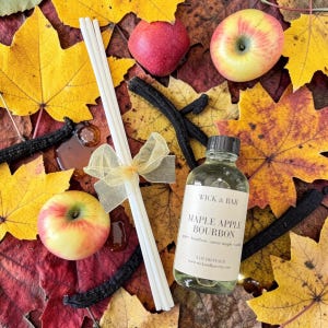 May include: A white ceramic mug with a black handle and the text "But First, Coffee" in a black, bold font. The mug is sitting on a wooden surface. The mug is approximately 4 inches tall.