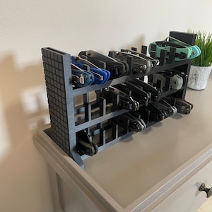 May include: A black plastic knife organizer with multiple slots for storing pocket knives. The organizer is filled with various pocket knives of different sizes and colors.