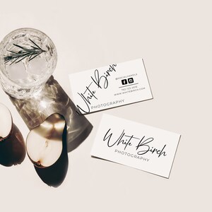 K&ouml;nnte beinhalten: Zwei wei&szlig;e Visitenkarten mit dem Text "White Birch Photography" in schwarzer Kursivschrift. Die obere Karte enth&auml;lt au&szlig;erdem Social-Media-Symbole und Kontaktinformationen.