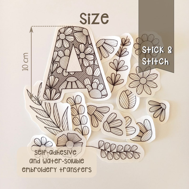 The stickers from the Floral Alphabet pack, spread out on the table. We have limited the height of the capital letter so you can see what it measures. It measures ten cm. Peel, stick, embroider and dissolve. Very easy to use