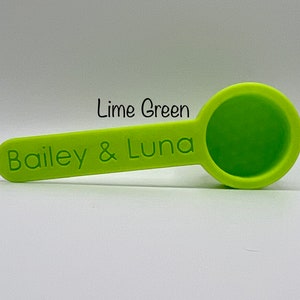 May include: Lime green measuring spoon with the text "Bailey & Luna" printed on the handle.