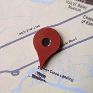 Könnte beinhalten: Ein roter Kartenmarker zeigt Sutton Creek Landing auf einer detaillierten Karte an. Die Karte zeigt Straßen, ein Museum und die Chapel of Ease. Der Marker hat eine dunkelbraune Mitte und ist über dem Ort positioniert.