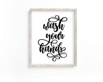May include: A white framed print with black calligraphy that reads "Wash your hands".