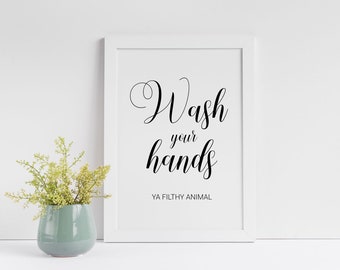 May include: White framed print with black text that reads "Wash your hands YA FILTHY ANIMAL".