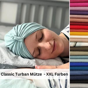 May include: A light mint green turban hat with gathered fabric detailing at the front. The image includes a vertical color palette strip on the right side displaying various fabric shades and the text Classic Turban M&uuml;tze - XXL Farben.