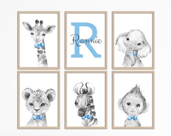 May include: Set of six nursery prints featuring black and white illustrations of a giraffe, elephant, lion, zebra, monkey, and the letter R in light blue with the name Ronnie. The prints have a light brown frame.