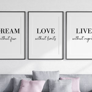 May include: Three black framed prints with white backgrounds and black text. The prints read "DREAM without fear", "LOVE without limits", and "LIVE without regrets".