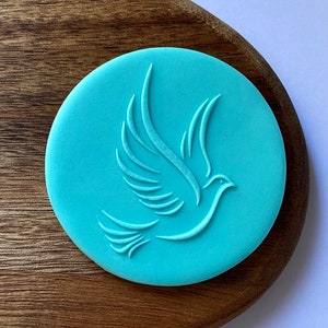 May include: A light blue silicone cookie cutter shaped like a dove in flight.
