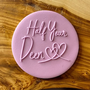 May include: A pink silicone stamp with the text "Half Your Deen" and two intertwined hearts.