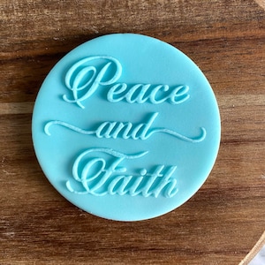 May include: A light blue round silicone stamp with the words "Peace and Faith" in a cursive font.