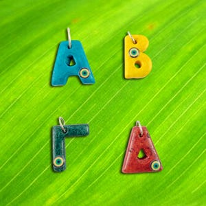 Dijes de monograma de cerámica griega y latina hechos a mano con iniciales de arcilla de color con acabado mate de mal de ojo Paquete de dos piezas