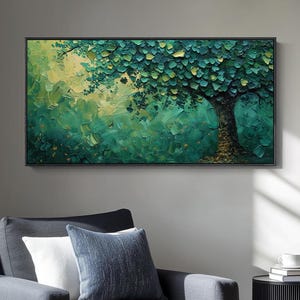 Puede incluir: Una pintura abstracta de un árbol con hojas verdes y amarillas y un tronco marrón cuelga sobre un sillón gris con almohadas. Una mesa auxiliar negra con libros y una taza está cerca.