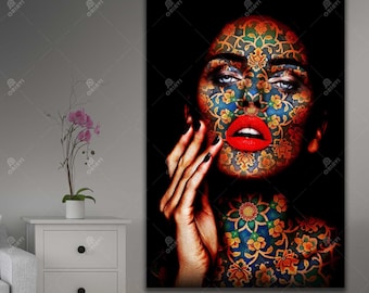 Puede incluir: La cara de una mujer está cubierta con un patrón colorido e intrincado. El patrón recuerda al arte islámico tradicional. Los ojos de la mujer son azules y sus labios están pintados de rojo brillante.