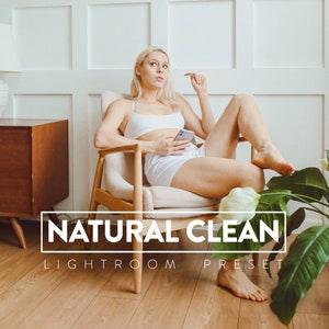 May include: A woman sits in a chair with a white top and white shorts. She is holding a phone in her hand. The text "NATURAL CLEAN LIGHTROOM PRESET" is on the floor in front of her.