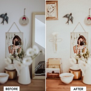 May include: A woman takes a selfie in a mirror, with white flowers in a vase in the foreground. The room is decorated in a bohemian style with framed artwork and a bird figurine on the wall.