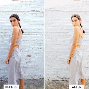 May include: A woman wearing a light grey linen crop top and matching skirt, standing in front of a white brick wall. The outfit is a two-piece set.