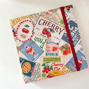 Może przedstawiać: Tkanina w kratę czerwoną i białą z vintage'owym wzorem przedstawiającym wiśnie, ciasta i lody. Tkanina zawiera tekst "Farm Fresh Cherry", "100% Organic Fruits", "Natural", "Fresh", "Home Made Cherry Pie" i "Pies".