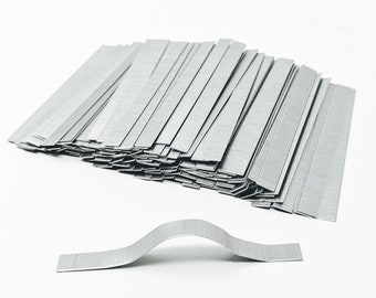 May include: A large stack of silver metal strips, with one strip bent into an arch shape. The strips are approximately 1 inch wide and 3 inches long.