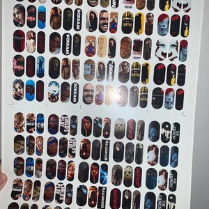 May include: Sheet of nail art transfers with horror film characters and titles. Designs include images from "The Shining," "Scream," "Nightmare on Elm Street," "Child's Play," "Halloween," and "The Exorcist."