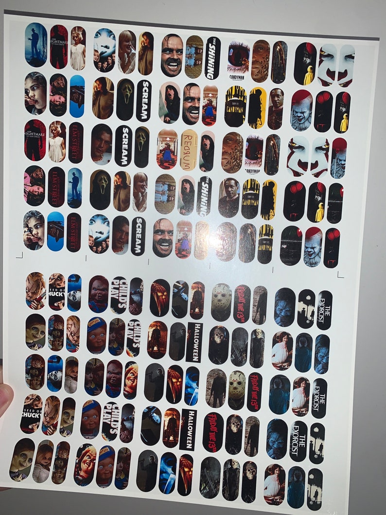 May include: Sheet of nail art transfers with horror film characters and titles. Designs include images from "The Shining," "Scream," "Nightmare on Elm Street," "Child's Play," "Halloween," and "The Exorcist."
