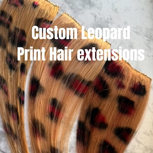 May include: Three custom leopard print hair extensions. The extensions are a light brown color with black and red leopard spots. The text "Custom Leopard Print Hair extensions" is in white.