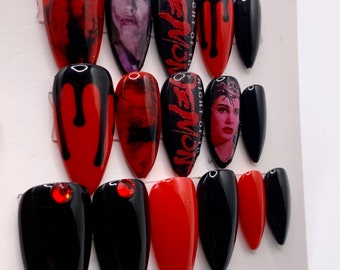 Puede incluir: Conjunto de 12 uñas postizas con varios diseños. Algunas uñas son negras con pintura roja goteando, algunas son rojas, algunas son negras con un diseño blanco y rojo, y algunas tienen una imagen de una mujer con el texto "Night of the Demon" en ellas.