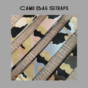 Pode incluir: Quatro alças de bolsa com diferentes padrões de camuflagem com detalhes de glitter dourado. As alças são feitas de tecido tecido e têm um esquema de cores preto, rosa, cinza e verde.