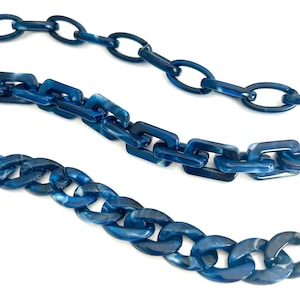 Puede incluir: Tres cadenas de plástico azul con un patrón de mármol. Las cadenas son de diferentes tamaños y estilos.