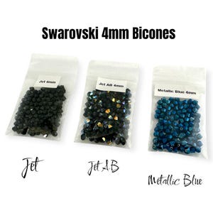 May include: Three bags of 4mm Swarovski bicones. The bags are labelled "Jet 4mm", "Jet AB 4mm", and "Metallic Blue 4mm".