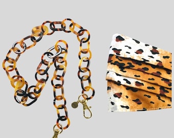 Op de afbeelding: Schildpad-maskerkette of brilketting met gouden sluitingen. De ketting is gemaakt van gekoppelde ovale vormen. De tekst "TORTOISE MASK CHAIN/GLASSES CHAIN" staat bovenaan de afbeelding.