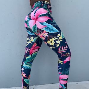 May include: A pair of dark blue leggings with a tropical floral print featuring pink, yellow, and green flowers. The leggings are made of a stretchy, comfortable fabric and are perfect for working out or lounging around the house.