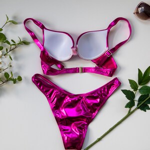 May include: A pink metallic bikini set with a push-up bra and a high-cut bottom.
