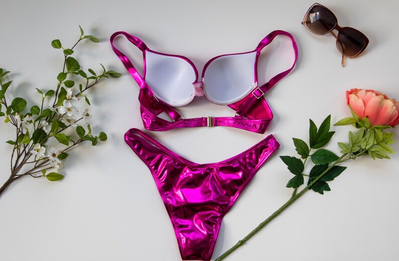 May include: A pink metallic bikini set with a push-up bra and a high-cut bottom.