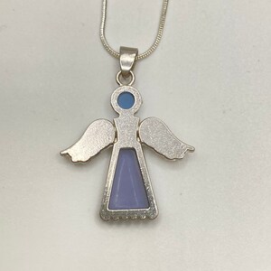 Op de afbeelding: Zilveren engel hanger ketting met een lichtblauwe en paarse steen. De engel heeft vleugels en een jurk.