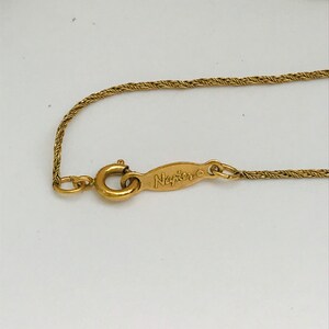 May include: A gold chain necklace with a clasp and a tag that reads "Napier".