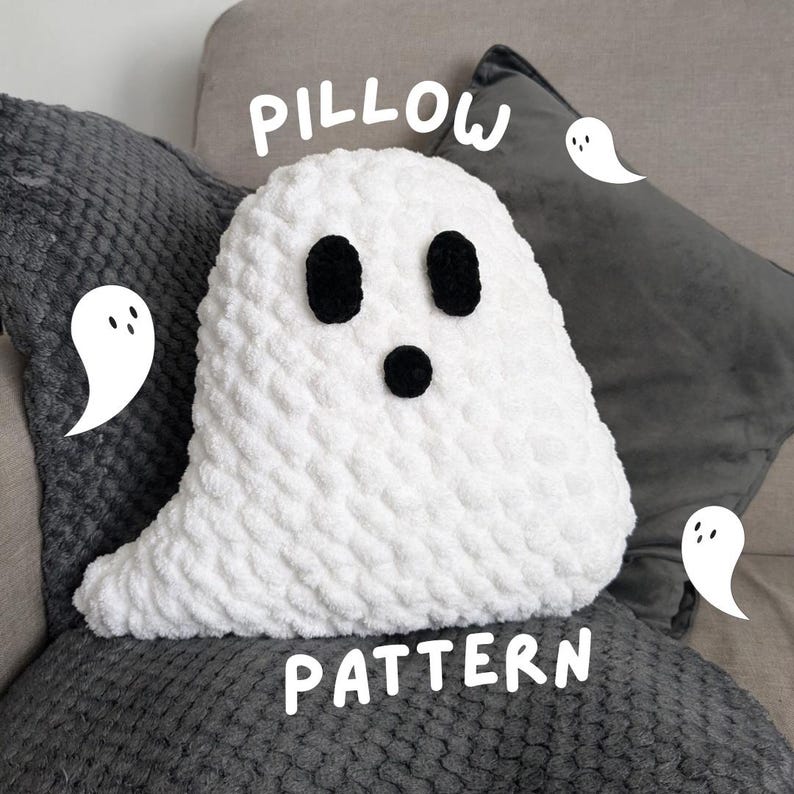 Puede incluir: Una almohada fantasma de crochet blanco con ojos negros y boca. La almohada est&aacute; sobre una superficie gris texturizada con las palabras "Pillow Pattern" escritas en blanco.