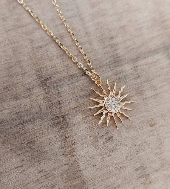 Collana color oro con ciondolo a forma di sole e barretta a T