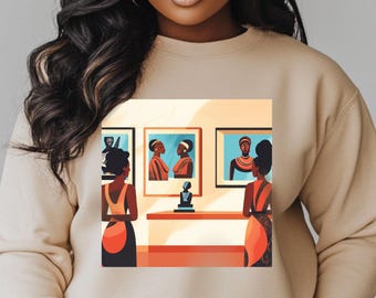 May include: A beige sweatshirt with a graphic print of two people looking at paintings in a gallery. The paintings feature portraits of Black women.