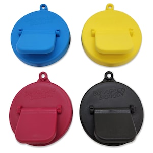 May include: Four beverage bottle stoppers in different colors: blue, yellow, red, and black. Each stopper has a flip-top lid and the words "Beverage Buddies" printed on the top.