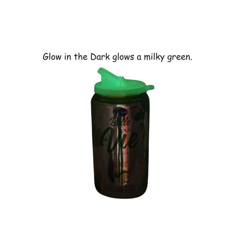 May include: A green glow-in-the-dark lid on a silver can with the text "Belle Vie" printed on it. Glow in the Dark glows a milky green.